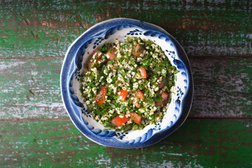 Tabouli salad on the old wooden background top view