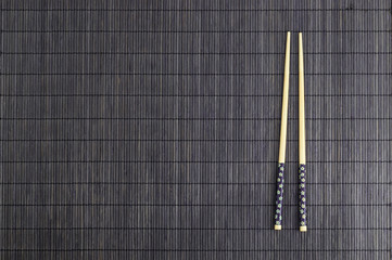 Wooden chopsticks on brown bamboo straw mat