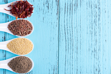 Four spoons containing asian ingredients, overhead, copy space