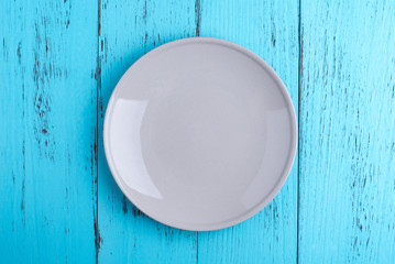 Empty plate centered on blue weathered wooden table