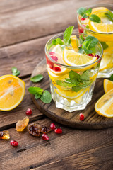 Lemon mojito cocktail with mint and pomegranate, cold refreshing drink or beverage