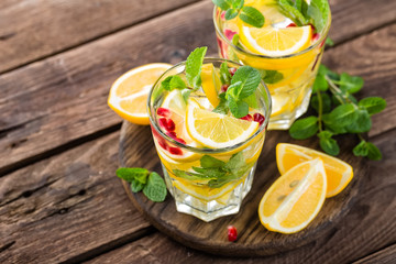 Lemon mojito cocktail with mint and pomegranate, cold refreshing drink or beverage