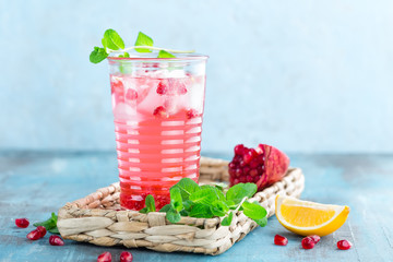 Infused pomegranate water with fresh lemon and ice, cold healthy refreshing and detox drink