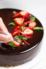 Female hands decorating cake