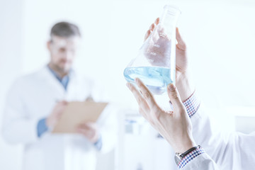 Scientist holding vessel with liquid