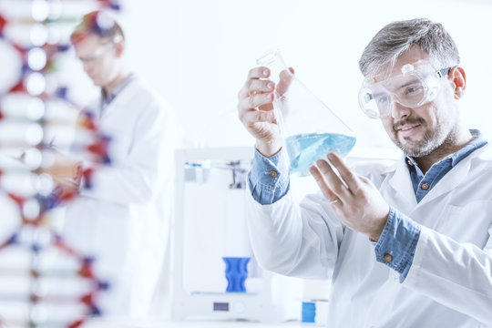 Chemist holding glass vessel