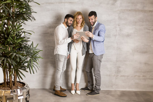Younge people with teblet by wall