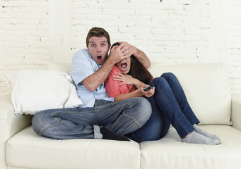 attractive couple having fun at home enjoying watching television horror movie show