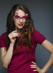 Attractive playful young woman with false glasses