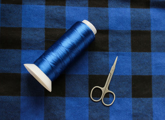Blue threat with scissors on a colorful fabric