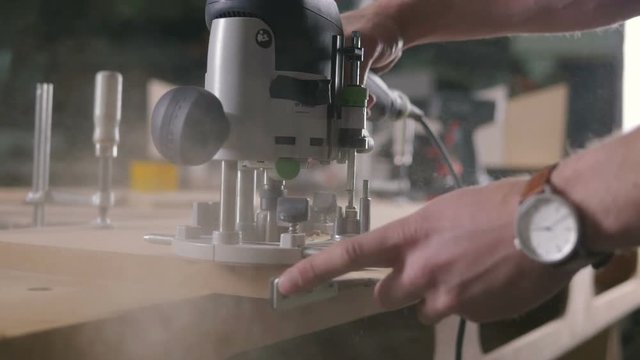 Young man working as carpenter and cutting board, slow motion