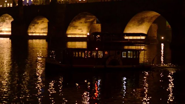small Boat crossing under the Charles Brigde in Prague