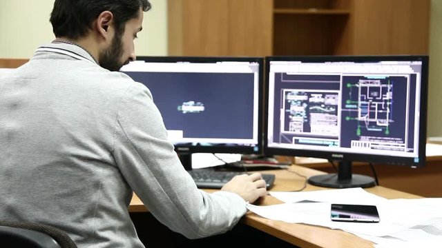 man with beard making blueprints on computer