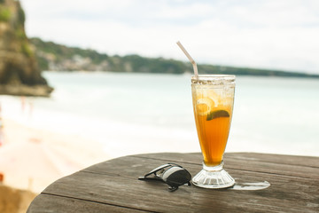 ice tea and glasses on wooden table at beach