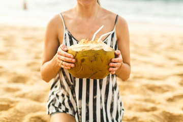 girl holds coconut in hand