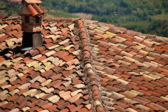 Blick über ein Dach mit roten Tonschindeln und kleinem Schornstein