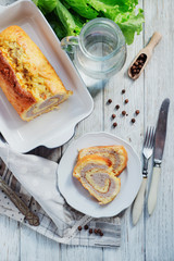 charcuterie, meat, baked chicken roll with egg omelette, peppers, herbs and salad leaves on a white wooden background 