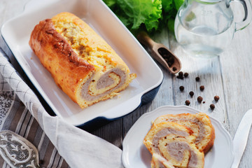 charcuterie, meat, baked chicken roll with egg omelette, peppers, herbs and salad leaves on a white wooden background 