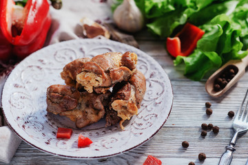 charcuterie, meat, baked pork rolls with egg omelet, Bulgarian red pepper, spice and lettuce on a wooden white background 