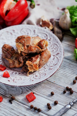 charcuterie, meat, baked pork rolls with egg omelet, Bulgarian red pepper, spice and lettuce on a wooden white background 