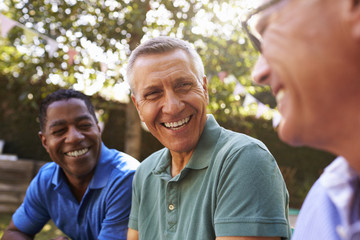 Mature Male Friends Socializing In Backyard Together - Powered by Adobe