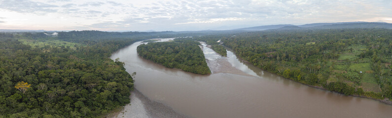 Aerial panorama of the Rio Napo in the Ecuadorian Amazon surrounded  by pristine rainforest. A farm cut out of the forest on the right bank.