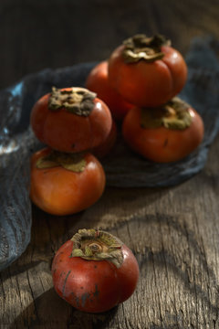 Persimmons stacked on wooden table