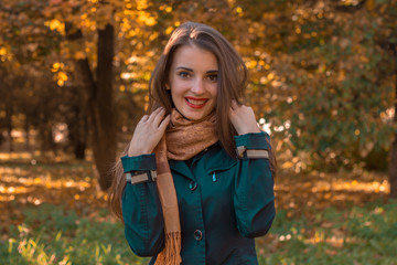 sweet girl stands in the park looks straight and smiling