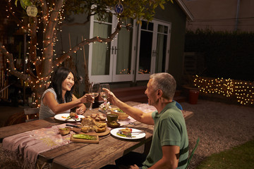 Mature Couple Enjoying Outdoor Meal In Backyard