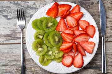 fresh strawberry and kiwi slices on cutting plate