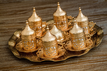 Traditional Golden Coffee Cup Set in a Tray on Wooden Background