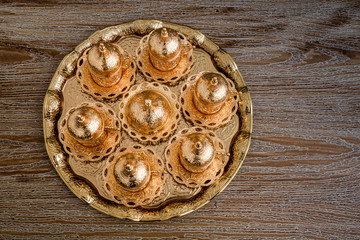 Traditional Golden Coffee Cup Set in a Tray on Wooden Background