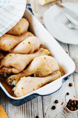 meat for dinner, baked chicken legs with spices, pepper and fresh white bread on wooden background 