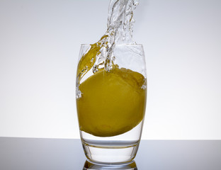 Zitrone - Limette fällt in das Wasser - Spritzer vor weissem Hintergrund