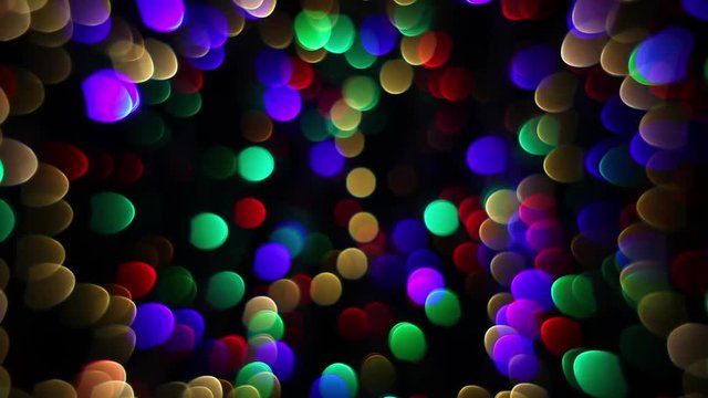 Abstract defocused holiday background. Decoration of blinking garlands. Christmas and new year lights twinkling. Celebration spirit in merry flashing colorful rings on dark night backdrop in HD clip.