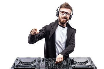 Young stylish man in glasses posing behind mixing console on white studio background.