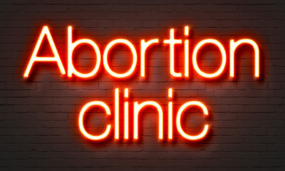 Fototapeta na wymiar Abortion clinic neon sign on brick wall background.