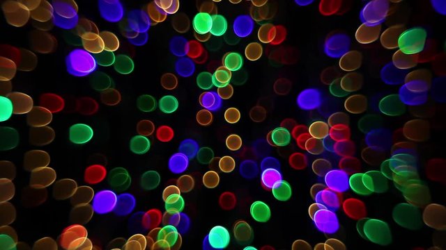Abstract bokeh holiday background. Decoration of blinking garlands. Christmas and new year lights twinkling. Celebration spirit in merry flashing colorful rings on dark night backdrop in full HD clip