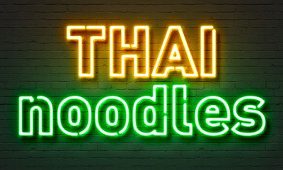 Thai noodles neon sign on brick wall background.