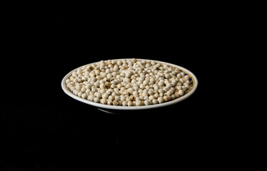 white pepper on the plate black background