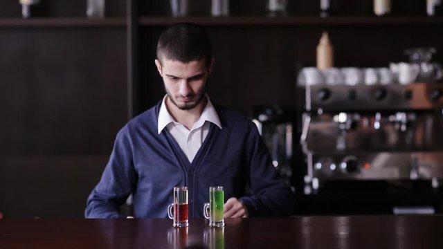 The bartender puts on the bar set of cocktails.