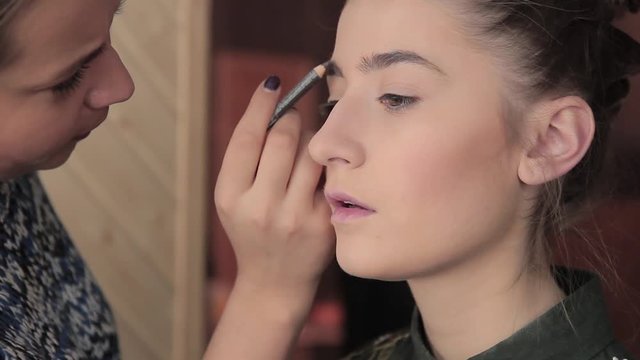 Eyebrow makeup for model in preparation for photography