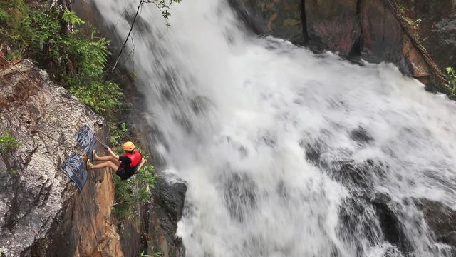 Climbers descend the steep cliff of Datanla waterfall. Dalat, Vietnam
