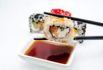 A piece of sushi held by chopsticks