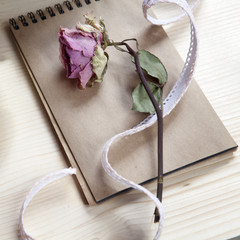 the Vintage notebook with a dry rose on the table