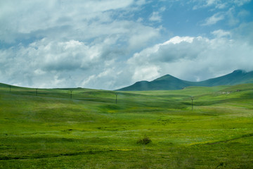 Green Hills and Meadiows, White Clouds and Mountains on the Horizon
