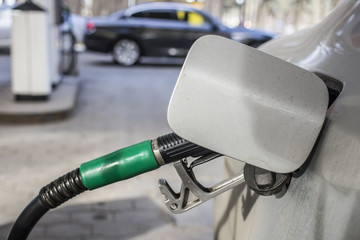 To fill the machine with fuel. Mashunya fill with gasoline at a gas station. Gas station pump. Man filling gasoline fuel in car holding nozzle. Close up