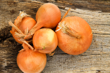 Whole onion bulbs on wooden background