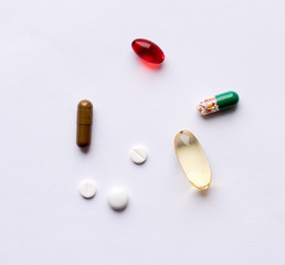 Tabs Vitamins, omega 3, Medications tablets and capsules in a beaker. Medications tablets, suppository bottles, capsules and thermometer on wooden table
