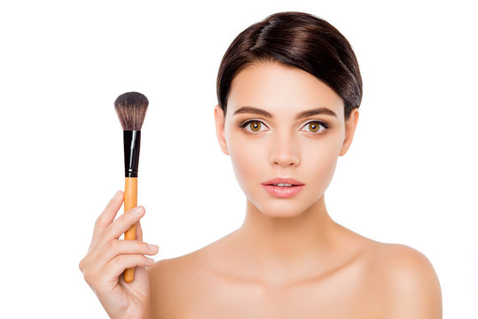 Portrait of young sensitive pretty woman showing make-up brush